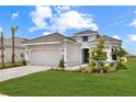 Charming single-story home showcasing a gray tile roof, manicured lawn, and beautiful landscaping at 15817 San Lazzaro Ave, Bradenton, FL 34211