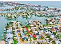 A stunning aerial view of a home in a vibrant neighborhood with waterfront access and city views at 17595 1St E St, Redington Shores, FL 33708