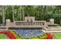Hunter's Green community entrance sign featuring lush landscaping and colorful flower beds at 17711 Hampshire Oak Dr, Tampa, FL 33647