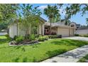 Charming single-story home featuring lush landscaping and a spacious three-car garage at 17711 Hampshire Oak Dr, Tampa, FL 33647