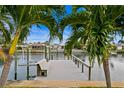 A wooden dock featuring a bench and a boat lift stretches out over the canal to provide water access at 1960 Montana Ne Ave, St Petersburg, FL 33703