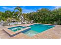 An inviting pool and spa with water views, surrounded by lush tropical landscaping and comfortable seating at 1960 Montana Ne Ave, St Petersburg, FL 33703
