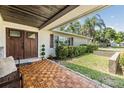 Inviting front porch with wood floors, a cozy bench, and a decorative front door at 2724 Ashwood Ct, Clearwater, FL 33761