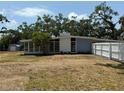 Back of the home featuring a white brick accent wall and surrounded by mature trees at 3000 58Th S Ave, St Petersburg, FL 33712