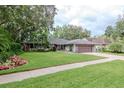 Inviting one-story home with lush lawn, mature landscaping, and a side-entry two-car garage at 3428 Valley Ranch Dr, Lutz, FL 33548
