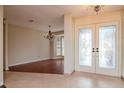 Bright foyer featuring decorative glass double doors, tile flooring, and chandelier at 3428 Valley Ranch Dr, Lutz, FL 33548