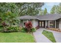 Close up of gray home with elegant landscaping, walkway, and double-door front entrance at 3428 Valley Ranch Dr, Lutz, FL 33548