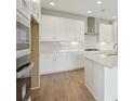 Bright kitchen with white cabinetry, stainless steel appliances, and a large quartz island at 3818 Farm Garden Ct, Lakewood Ranch, FL 34211