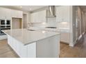 Bright kitchen with white cabinetry, stainless steel appliances, and a large quartz island at 3818 Farm Garden Ct, Lakewood Ranch, FL 34211