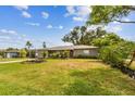 Attractive single-story home showcasing a lush green lawn and mature trees at 5245 18Th N St, St Petersburg, FL 33714