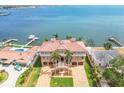 Aerial view of a grand waterfront estate with lush landscaping and a terracotta tile roof at 5810 Mariner St, Tampa, FL 33609