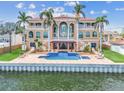 Luxury waterfront home featuring a pool with a waterfall and pergola at 5810 Mariner St, Tampa, FL 33609