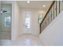 Bright entryway with tile floors, staircase with decorative iron railing, and ample natural light at 5933 Caldera Ridge Dr, Lithia, FL 33547