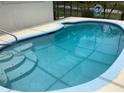 Inviting backyard pool with clear blue water and easy-access steps perfect for summertime relaxation at 6488 Robinswood Ave, Brooksville, FL 34602
