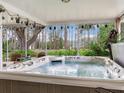 Relaxing covered hot tub with a view of lush greenery, perfect for unwinding in privacy and comfort at 7216 N Mobley Rd, Odessa, FL 33556