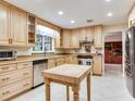 Bright eat-in kitchen with natural wood cabinetry, stainless steel appliances, and center island at 7216 N Mobley Rd, Odessa, FL 33556