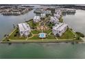 Aerial view of a luxury condo community with a central pool and manicured lawns on a peninsula surrounded by water at 7922 Sailboat Key S Blvd # 608, South Pasadena, FL 33707