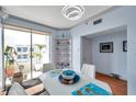 A dining room with a white table, white chairs, a decorative shelf, and sliding glass doors to the outdoor balcony at 7922 Sailboat Key S Blvd # 608, South Pasadena, FL 33707