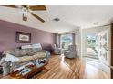 Cozy living room with wood laminate flooring, ceiling fan, and view to the front yard at 8305 Palencia Dr, Port Richey, FL 34668