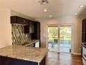Bright kitchen features stainless steel appliances, granite counters, and backyard view at 9893 86Th N Way, Seminole, FL 33777