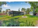 Expansive backyard with a screened-in porch and fire pit, perfect for outdoor entertaining at 9981 58Th N St, Pinellas Park, FL 33782