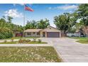 Charming one-story home with manicured lawn and a prominent American flag at 9981 58Th N St, Pinellas Park, FL 33782