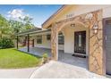 Stone-accented entryway with a covered porch, providing a welcoming entrance to the home at 9981 58Th N St, Pinellas Park, FL 33782