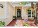 Inviting front entrance with brick walkway, decorative columns, and security system. The door has glass accent and transom window at 10150 Heather Sound Dr, Tampa, FL 33647