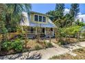 Charming two-story home with a metal roof, a quaint front yard, and a picket fence at 1038 Crescent Lake N Dr, St Petersburg, FL 33701