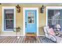 Welcoming front porch with outdoor seating, blue trim, and a blue front door with glass at 1038 Crescent Lake N Dr, St Petersburg, FL 33701