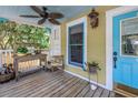 Inviting covered front porch with a ceiling fan, a table and chair set, and a blue front door at 1038 Crescent Lake N Dr, St Petersburg, FL 33701