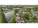 An aerial view of a home with a pond, mature trees, and a well-maintained neighborhood at 10430 42Nd N St, Clearwater, FL 33762