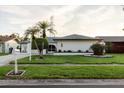 Charming single-story home with a well-manicured lawn and mature landscaping at 10430 42Nd N St, Clearwater, FL 33762