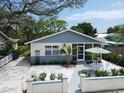 Inviting single story home featuring a beautiful front yard and quaint outdoor seating area at 106 E Cedar St, Tarpon Springs, FL 34689