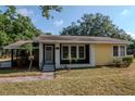 Inviting home with a covered front porch, black and yellow exterior, and well-maintained landscaping at 108 E Morgan St, Brandon, FL 33510