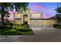 Charming two-story home featuring a manicured lawn, three-car garage, and covered entryway at 10837 Breaking Rocks Dr, Tampa, FL 33647