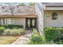 Inviting front entrance features manicured shrubs, and a walkway leading to a double-door entryway with glass panels at 1103 Old Mill Pond Rd, Palm Harbor, FL 34683