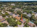 A home featuring a pool with mature landscaping throughout the neighborhood at 1212 Royal Oak Dr, Dunedin, FL 34698