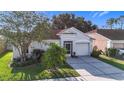 Charming single-story home featuring a well-manicured lawn, screened entry, and attached garage at 12426 Dawn Vista Dr, Riverview, FL 33578