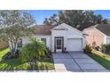 Charming single-story home featuring a well-manicured lawn, screened entry, and attached garage at 12426 Dawn Vista Dr, Riverview, FL 33578