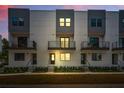 Townhouse exterior at dusk featuring modern design, balconies, and manicured landscaping at 1316 W Carmen St # 2, Tampa, FL 33606