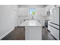 Modern kitchen featuring white cabinets, stainless steel appliances, and large island with quartz countertop at 1316 W Carmen St # 2, Tampa, FL 33606