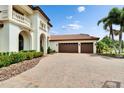 Elegant home with a three-car garage, brick-paved driveway, red tile roof and well-manicured landscaping at 16406 Chapman Crossing Dr, Lithia, FL 33547