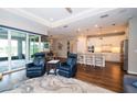 Open-concept living room with hardwood floors, and a modern kitchen with stainless steel appliances at 19877 Sea Glass Cir, Land O Lakes, FL 34638