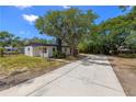 Inviting home featuring a neutral exterior, a new concrete driveway, and mature trees, perfect for outdoor enjoyment at 2157 20Th Sw Ave, Largo, FL 33774