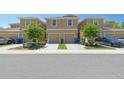 View of two-story townhomes featuring attached garages, manicured lawns, and inviting curb appeal at 2234 Lennox Dale Ln, Brandon, FL 33510
