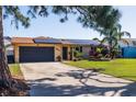 Lovely single Gathering home featuring a well-manicured lawn, solar panels, and attached garage at 2401 66Th S Ave, St Petersburg, FL 33712