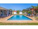 Backyard pool featuring beautiful brick deck, privacy fence, outdoor pergola, and lush landscaping at 2401 66Th S Ave, St Petersburg, FL 33712