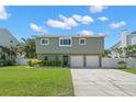 Charming two-story home with a well-manicured lawn and a two-car garage, creating an inviting curb appeal at 261 Kentucky Ave, Crystal Beach, FL 34681