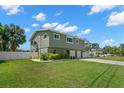 The manicured lawn and white fence enhance curb appeal, complementing the home's exterior at 261 Kentucky Ave, Crystal Beach, FL 34681